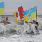 Άνδρες με ουκρανικές σημαίες βουτούν στα παγωμένα νερά για τον εορτασμό των Θεοφανείων στην Οδησσό κι ενώ η Ουκρανία βρίσκεται σε πόλεμο μετά την ρωσική εισβολή στα εδάφη της