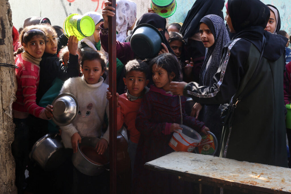 Παιδιά από την Παλαιστίνη περιμένουν να λάβουν φαγητό που μαγειρεύεται από μία φιλανθρωπική κουζίνα εν μέσω ελλείψεων σε τρόφιμα