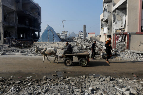 Ένα γαϊδούρι που τραβάει ένα κάρο, περνάει μπροστά από τα ερείπια ενός σπιτιού που καταστράφηκε από ισραηλινό χτύπημα στη Γάζα