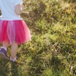 παιδί με ροζ τουτου φούστα περπατάει σε γρασίδι - όμως δεν φορά κάτι από ουδέτερη μόδα