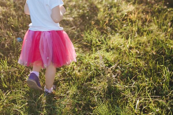 παιδί με ροζ τουτου φούστα περπατάει σε γρασίδι - όμως δεν φορά κάτι από ουδέτερη μόδα