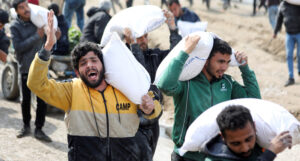 Παλαιστίνιοι μεταφέρουν σακούλες με αλεύρι, καθώς οι κάτοικοι της Γάζας αντιμετωπίζουν κρίσιμα επίπεδα πείνας