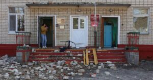 Μία γυναίκα στέκεται στην είσοδο ενός κτηρίου νηπιαγωγείου στο Μπέλγκοροντ της Ρωσίας που επλήγη από βομβαρδισμό