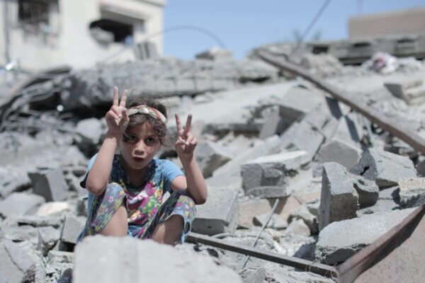 Παιδί στα συντρίμμια της Γάζας σχηματίζει το σήμα της ειρήνης με τα χέρια του