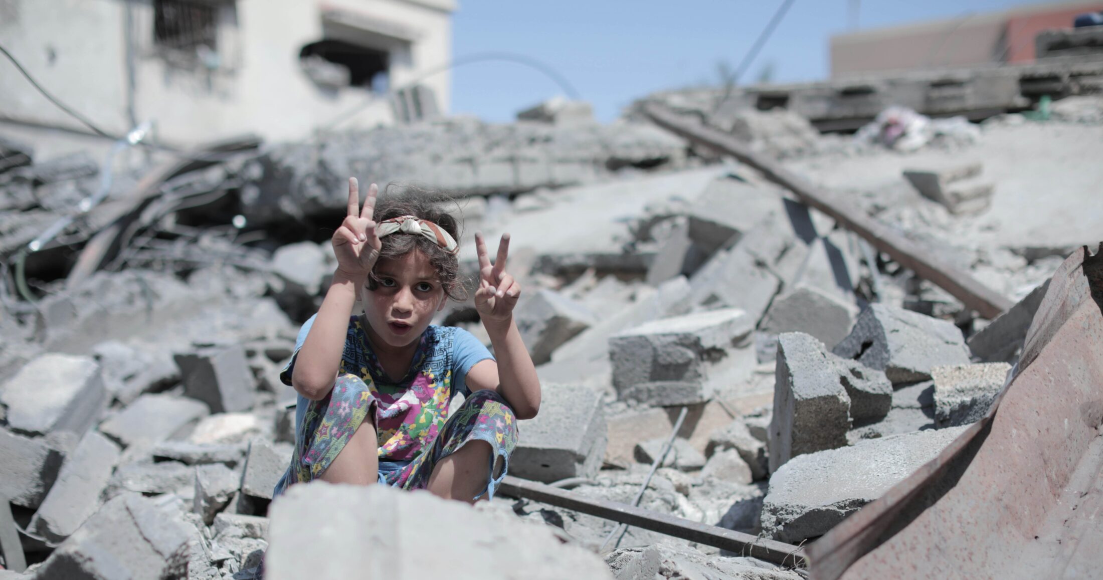 Παιδί στα συντρίμμια της Γάζας σχηματίζει το σήμα της ειρήνης με τα χέρια του